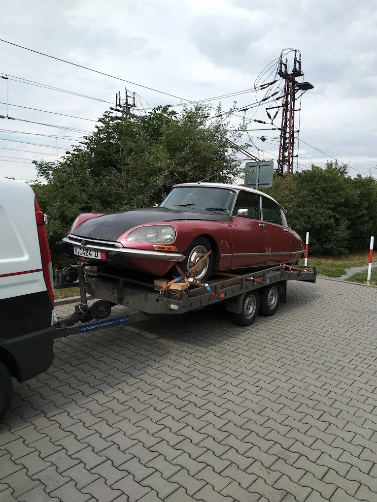 Veterán Citroën DS naložený a upoutaný na autopřepravníku z půjčovny